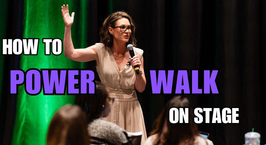 Kathryn Janicek walks across the stage in an audience of women.